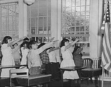 Photograph of school kids in 1941 performing what looks like a Hitler salute, except towards a US flag.